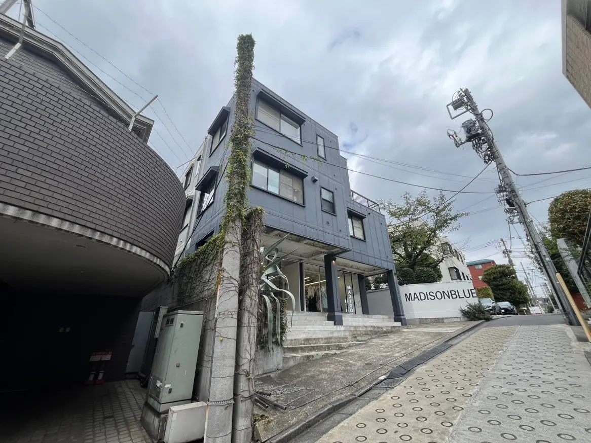 現代的な外観の都市型ビルと周囲の歩道、テクスチャーの壁面と都会的な環境