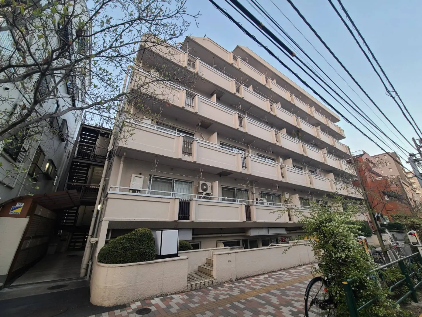 日本の都市部にある多階建てのマンション、バルコニーが付いている外観、明るい昼間の景色