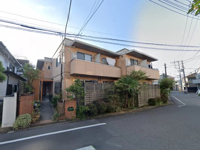 - 自然に囲まれた住宅街のアパートメント外観、緑豊かな植栽と穏やかな通りの様子