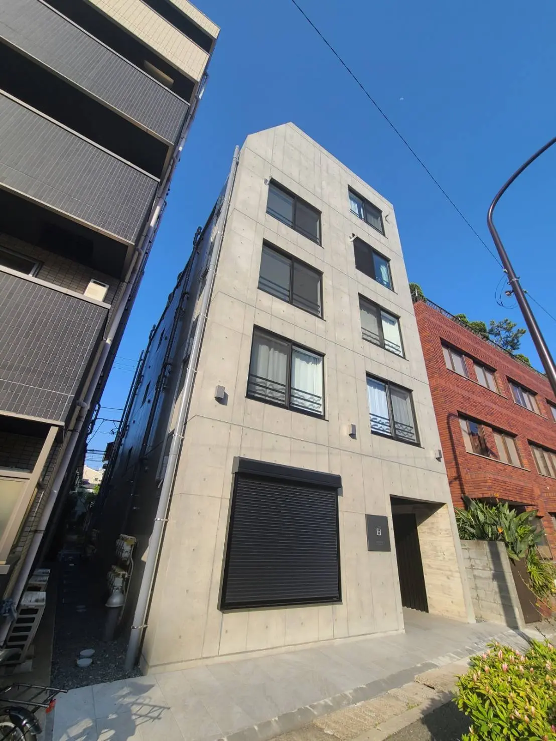 シンプルでモダンなデザインの都市型アパートメント、晴天の日差しを受ける外観