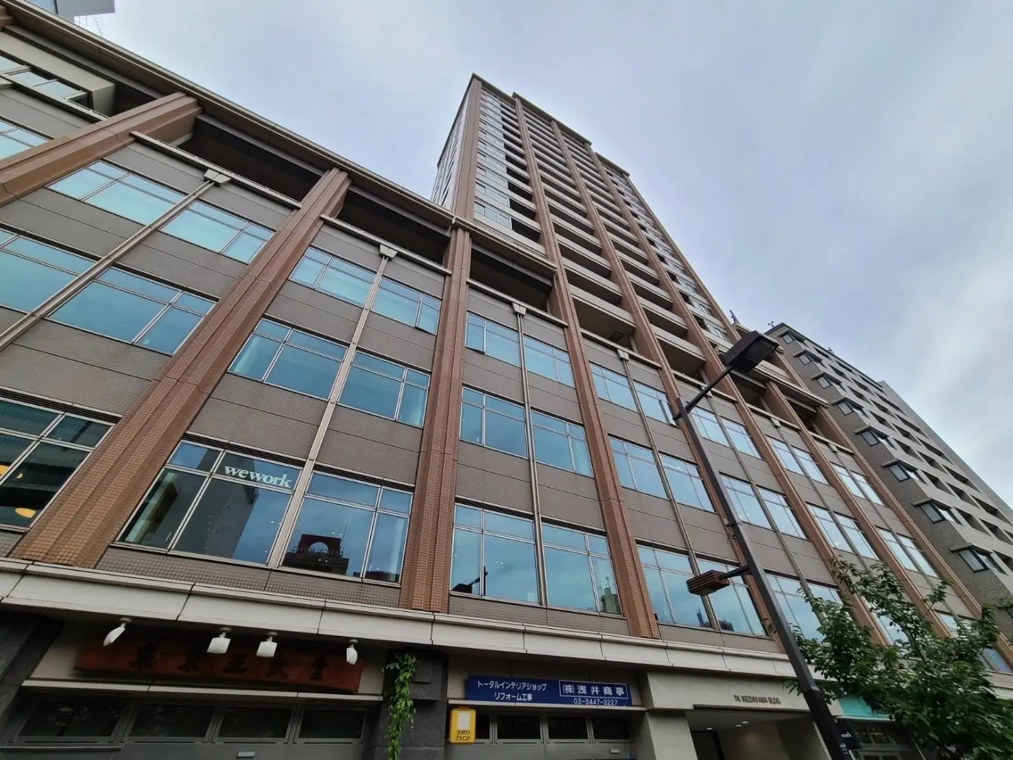 現代的なデザインのオフィスビル外観、WeWorkの看板が掲げられたビル、都市風景