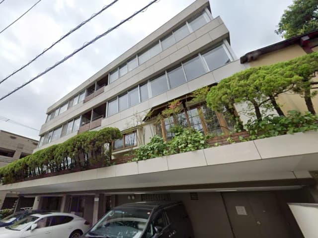 都市部にある現代的なデザインのアパート建物、ベランダに緑植物が飾られている外観