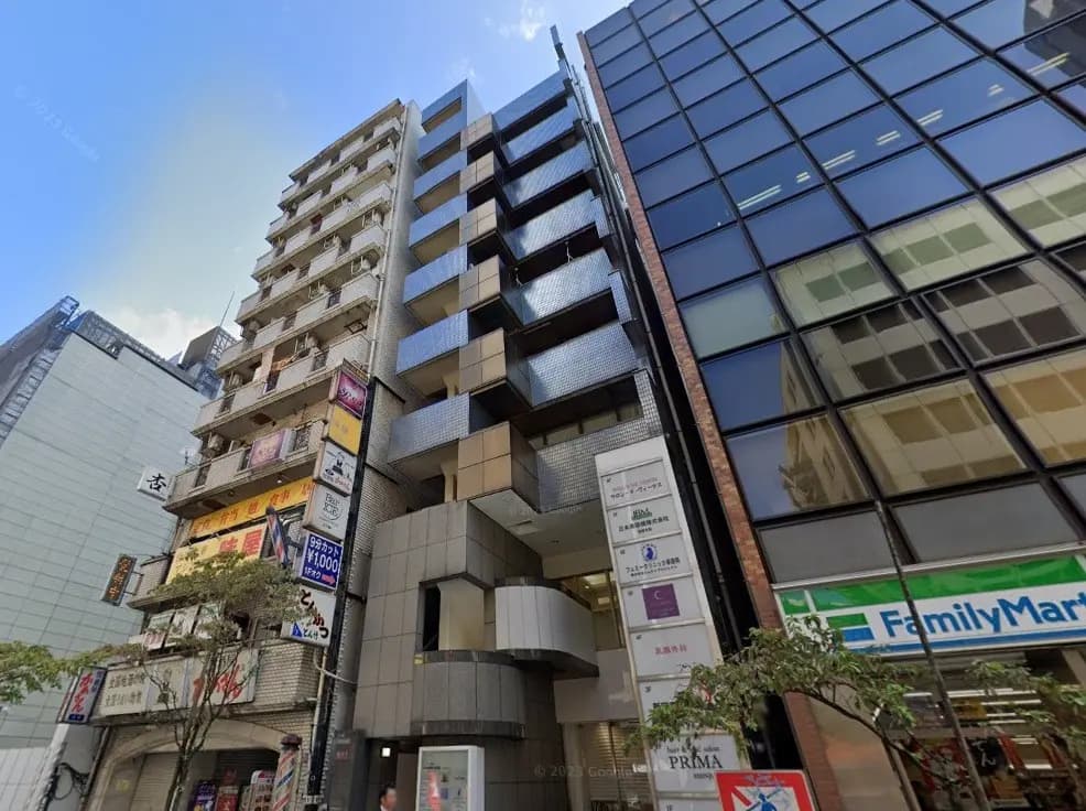 日本の都市部にある商業ビルとアパートメント、店舗看板とFamilyMartコンビニの入った現代的な建築デザイン