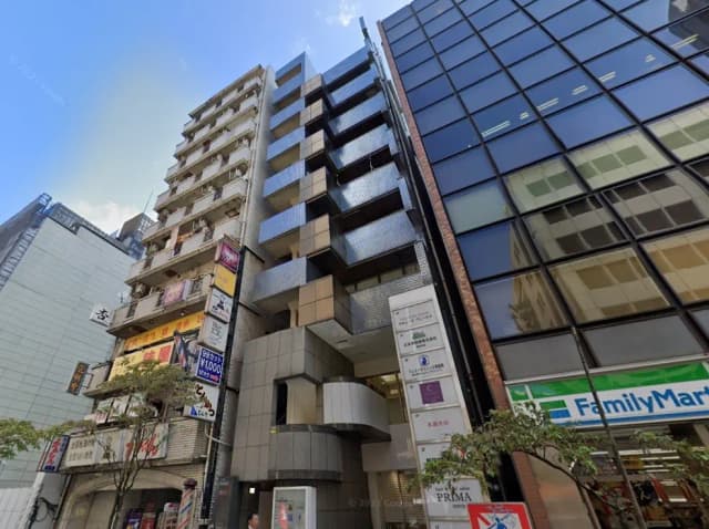 日本の都市部にある商業ビルとアパートメント、店舗看板とFamilyMartコンビニの入った現代的な建築デザイン