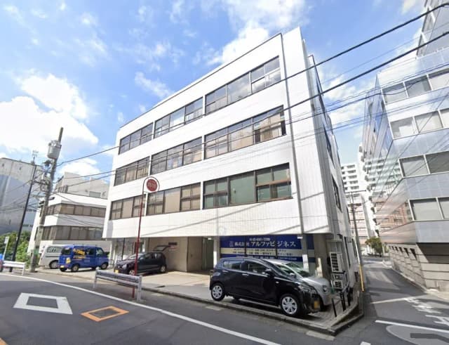 日本の都市部に位置するモダンなオフィスビル、晴れた日の街角、駐車場付き