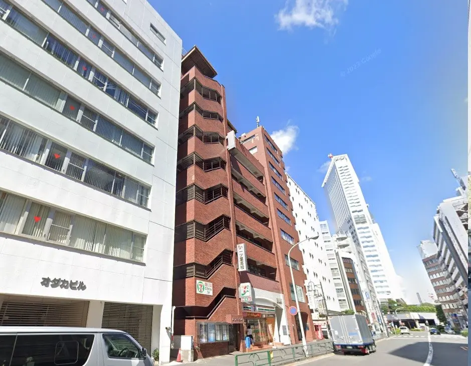 日差しが降り注ぐ晴れた日の都市風景、煉瓦色の建物と近代的な高層ビル、青空と都市の建築物
