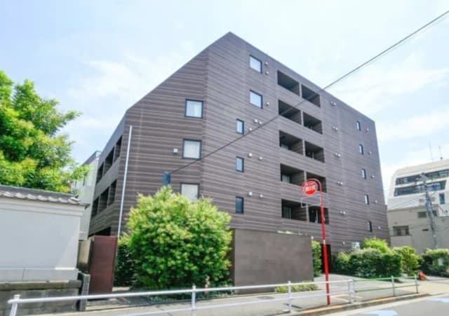 - モダンな外観のアパートメントビル、透過的な大きな窓と周囲の緑が調和したデザイン