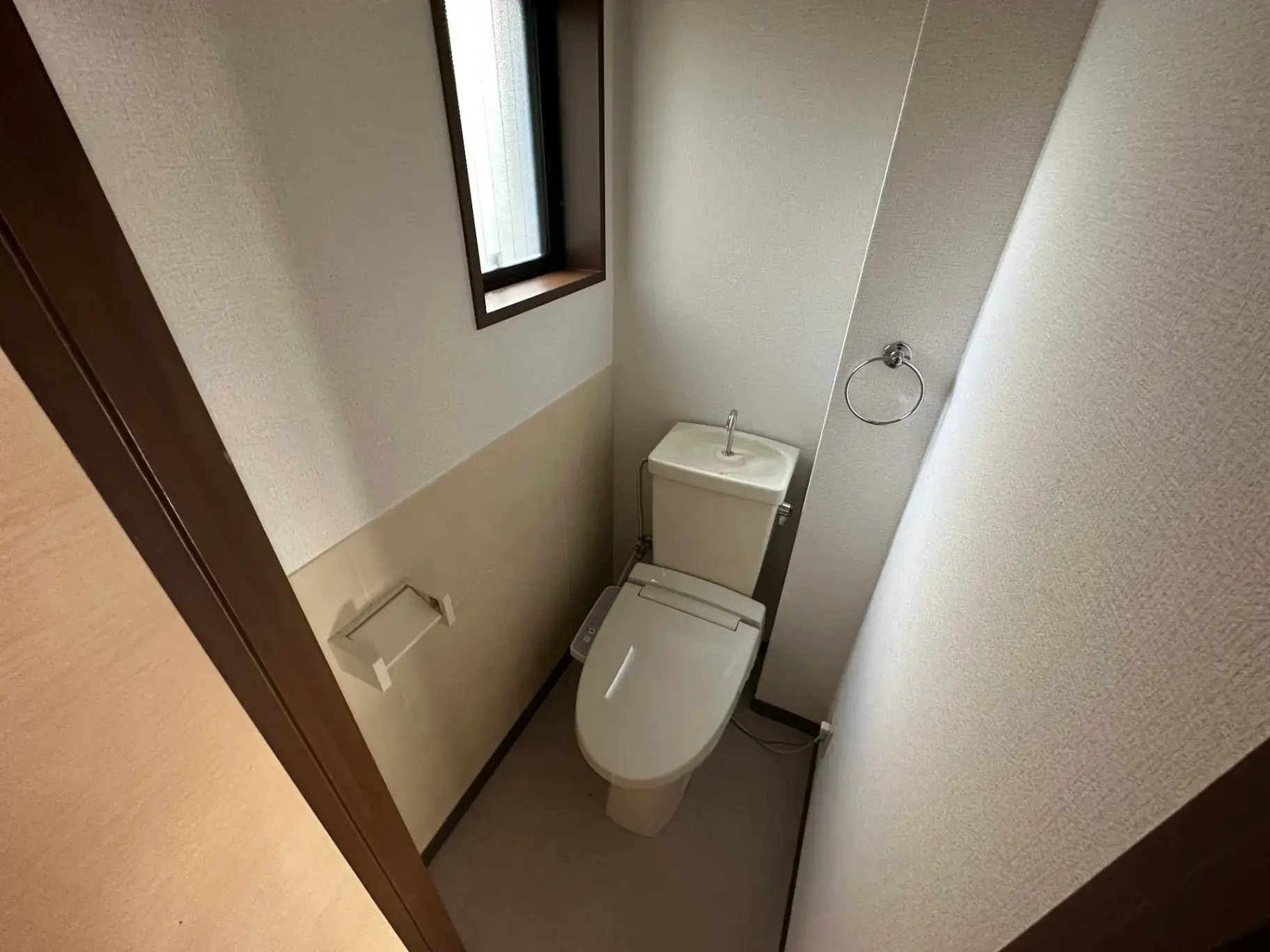 自然光が入る窓付きのコンパクトなトイレの風景