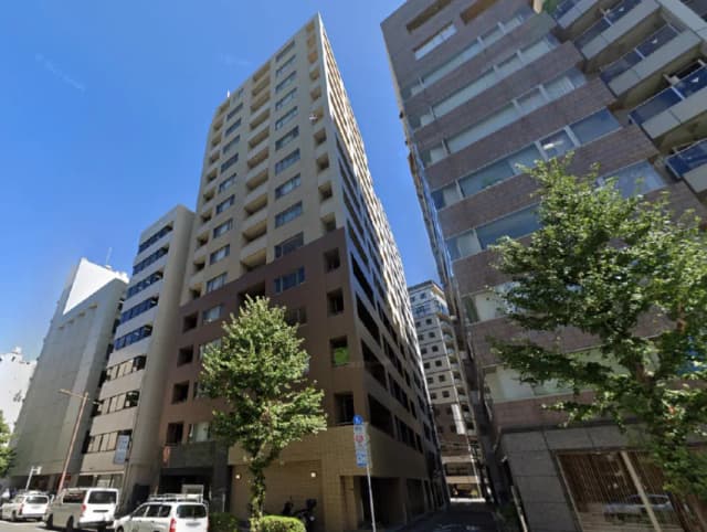 - モダンな高層ビルが立ち並ぶ街並み、青空の下での住宅エリアの風景、緑豊かな街路樹と車が見えるシーン