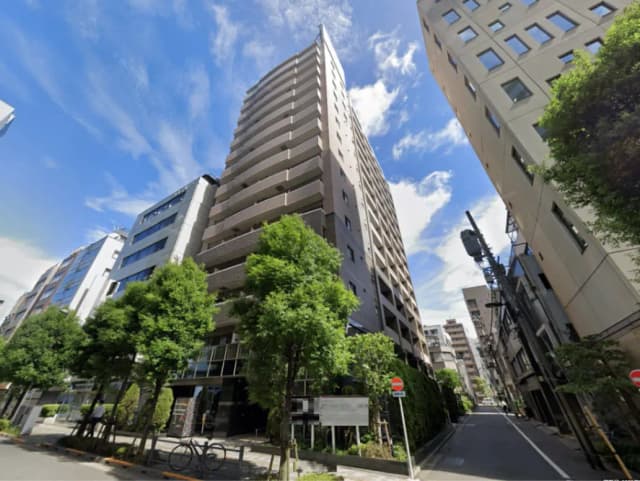- 現代的なデザインの高層マンション、緑豊かな街路樹と晴れた青空の下に位置する都市の風景