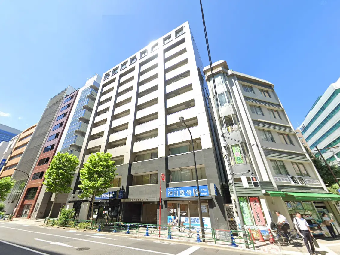 - 現代的なビルが並ぶ東京都内の街並み、青空と大きな木々が印象的な風景