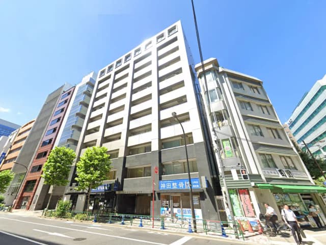 - 現代的なビルが並ぶ東京都内の街並み、青空と大きな木々が印象的な風景