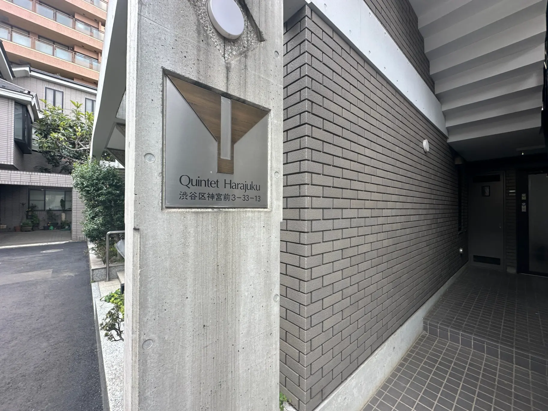 原宿の高級マンションQuintetのエントランス、コンクリートと煉瓦の壁、ステンレス製の看板