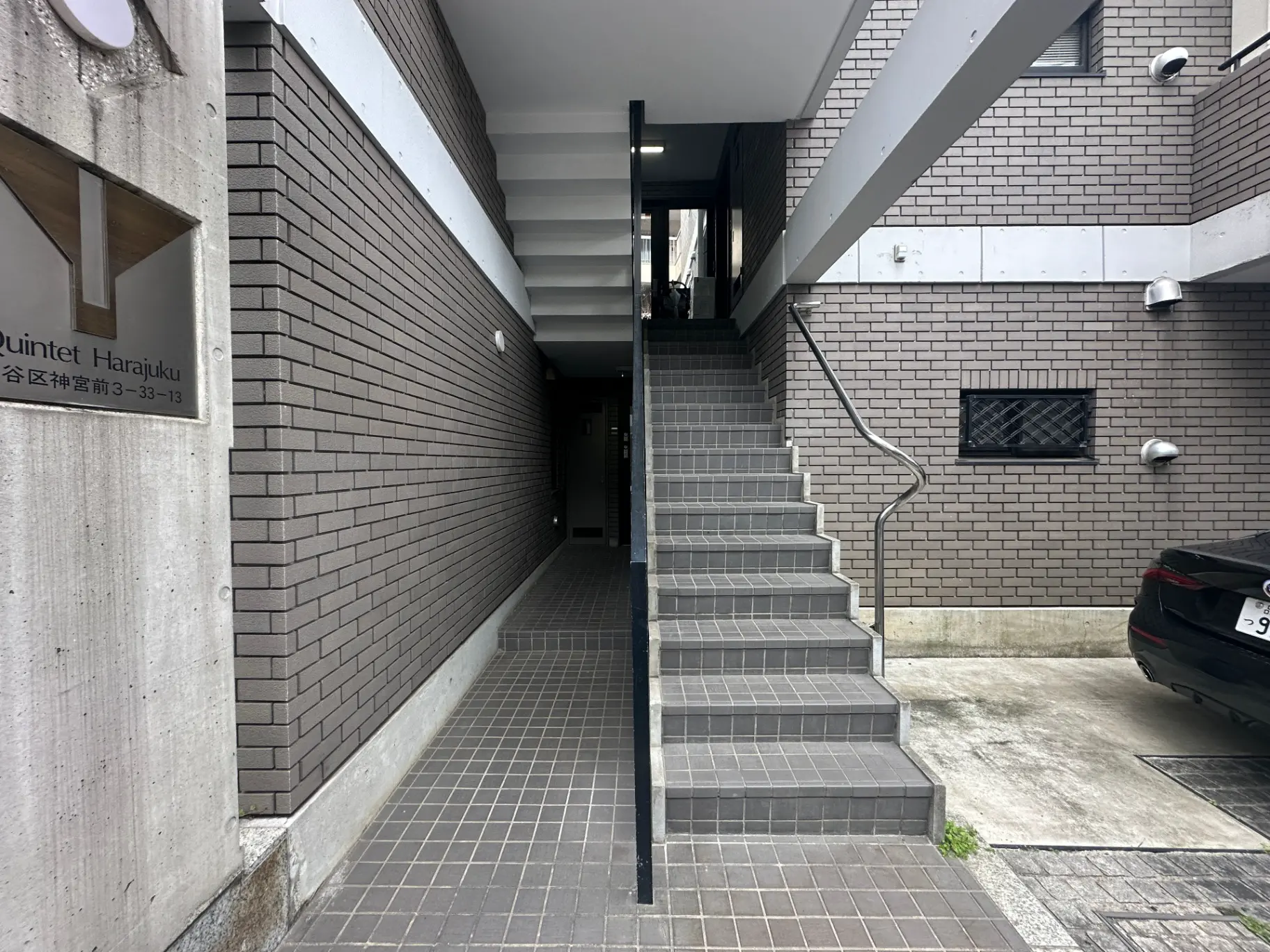 原宿のモダンな外観の建物、クインテット原宿、駐車場と階段があるエントランス