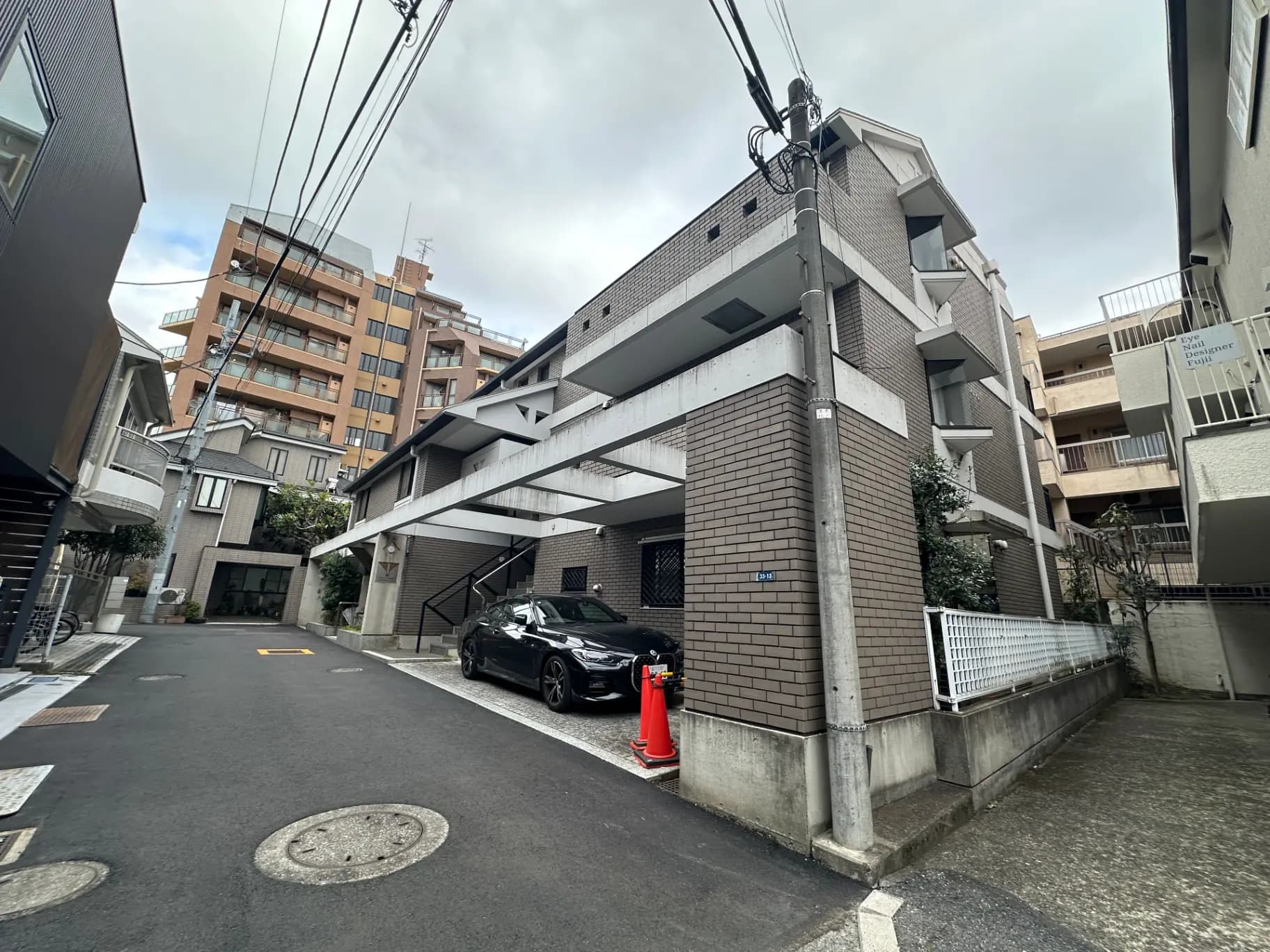 都市の中での住宅街の通り、近代的な建築のアパートメントビルと駐車された車