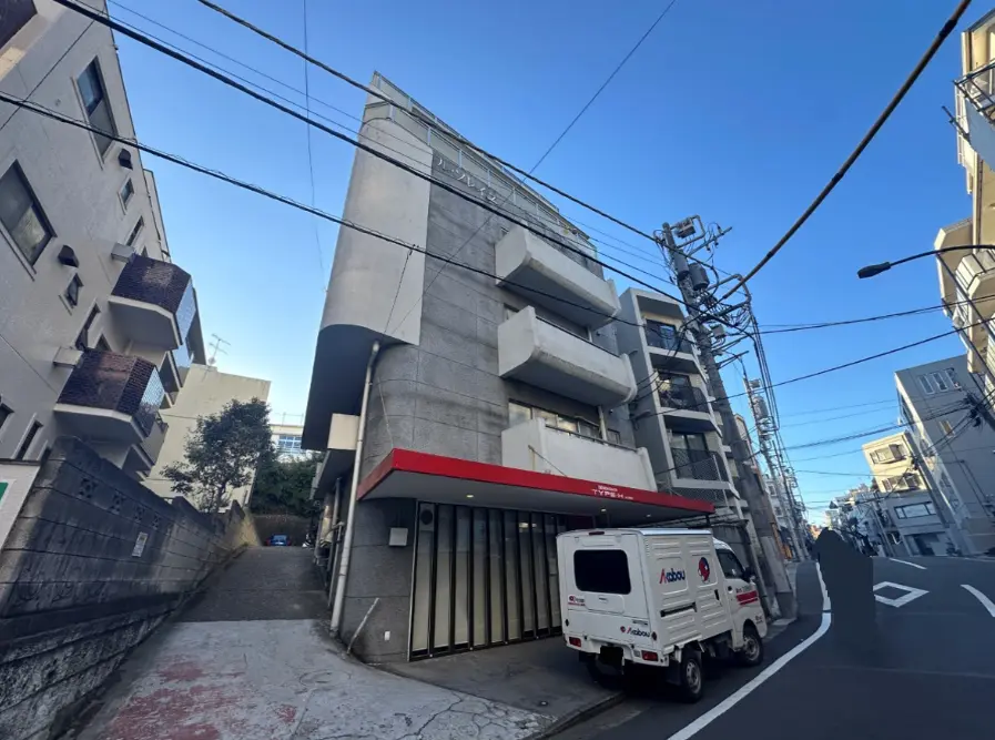 都会的な景観の中にあるモダンな建築物と配送車、青空と電線が交差する街角