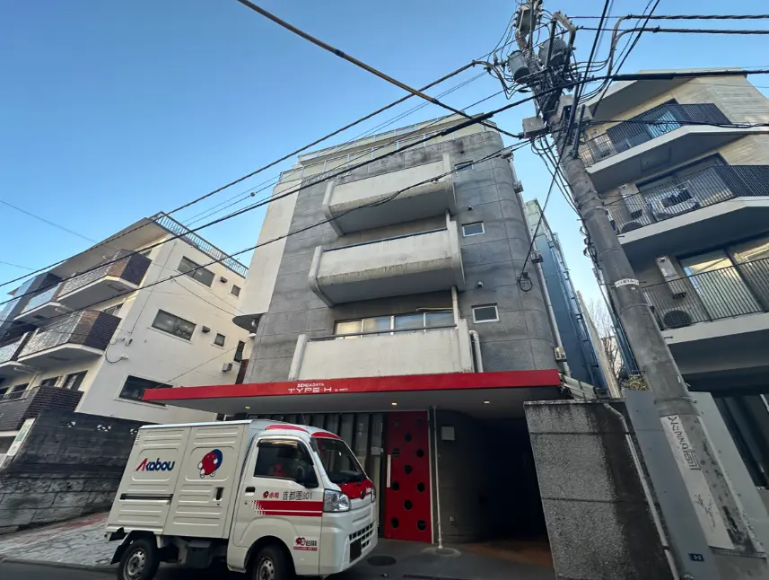 都会の建物とアパートメント、前に配送業者のトラックが停まっているストリートビュー