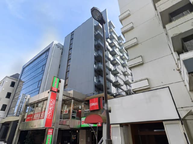 - 都市の風景に立つ現代的なビルと飲食店のファサード、周囲の高層ビルとのコントラストが際立つ街並み