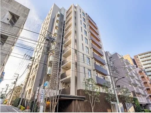 現代的なマンションの外観、都市の住宅街に位置し、電線が交差するクリアな青空