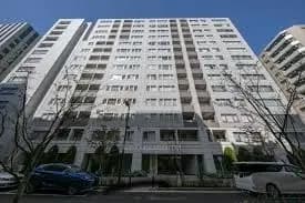 現代的なマンションの外観、都市の住宅街に位置する白い建物