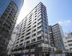 都市の中の現代的なマンションビル、ガラスとコンクリートのファサード、周囲に高層ビル