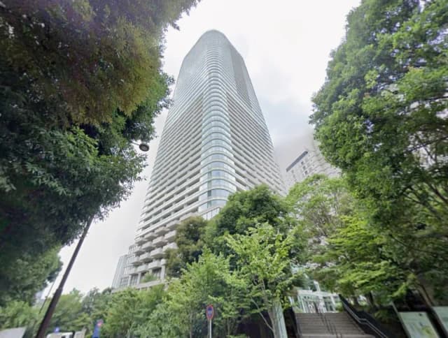 都市の緑豊かな公園から見上げる高層ビルの外観、現代的なアーキテクチャと自然の調和