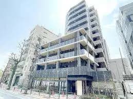現代的な外観のオフィスビル、街路樹が立ち並ぶ都市の通りに位置する