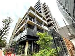現代的な外観の高層マンション、緑豊かな植栽とクリアな空、都会的な建築スタイル