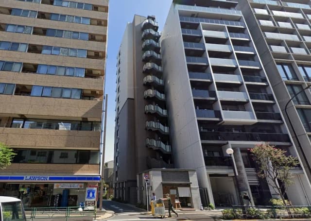 日中の都市風景、モダンなマンション建物とコンビニエンスストア、歩行者と青空