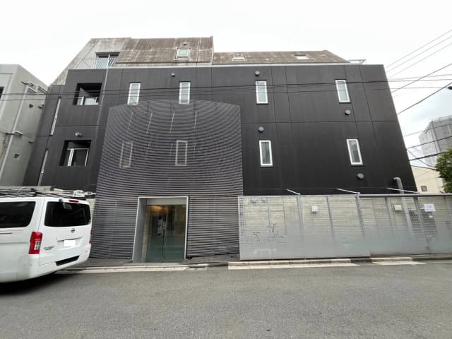 現代的なデザインの黒い外壁を持つ都市型アパートメントビル、駐車スペースあり