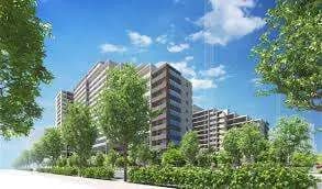 新築マンションの外観、木々に囲まれた通りと青空、モダンな建築スタイル