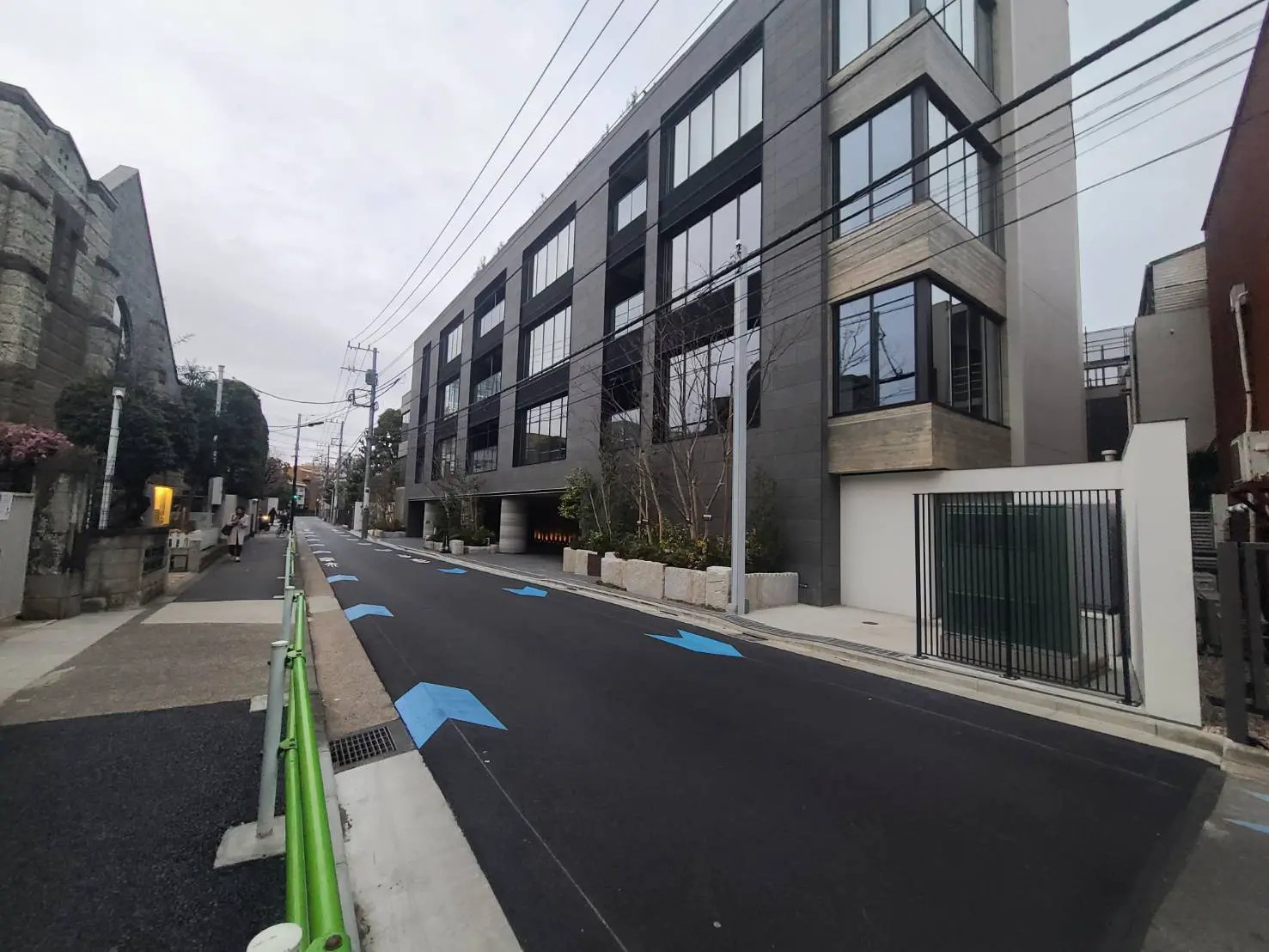 都市の閑静な住宅街に位置する現代的なデザインの建物、清潔で整備された歩道と自転車レーン