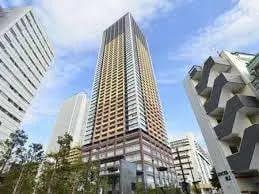 近代的な高層ビル、周囲には他のオフィスビル、青い空と都市のスカイライン