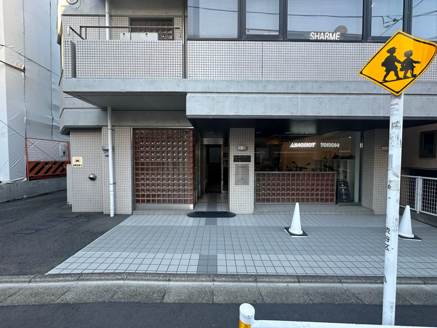 日本の都市部のビルの外観、歩行者専用地域を示す標識、タイル張りの歩道