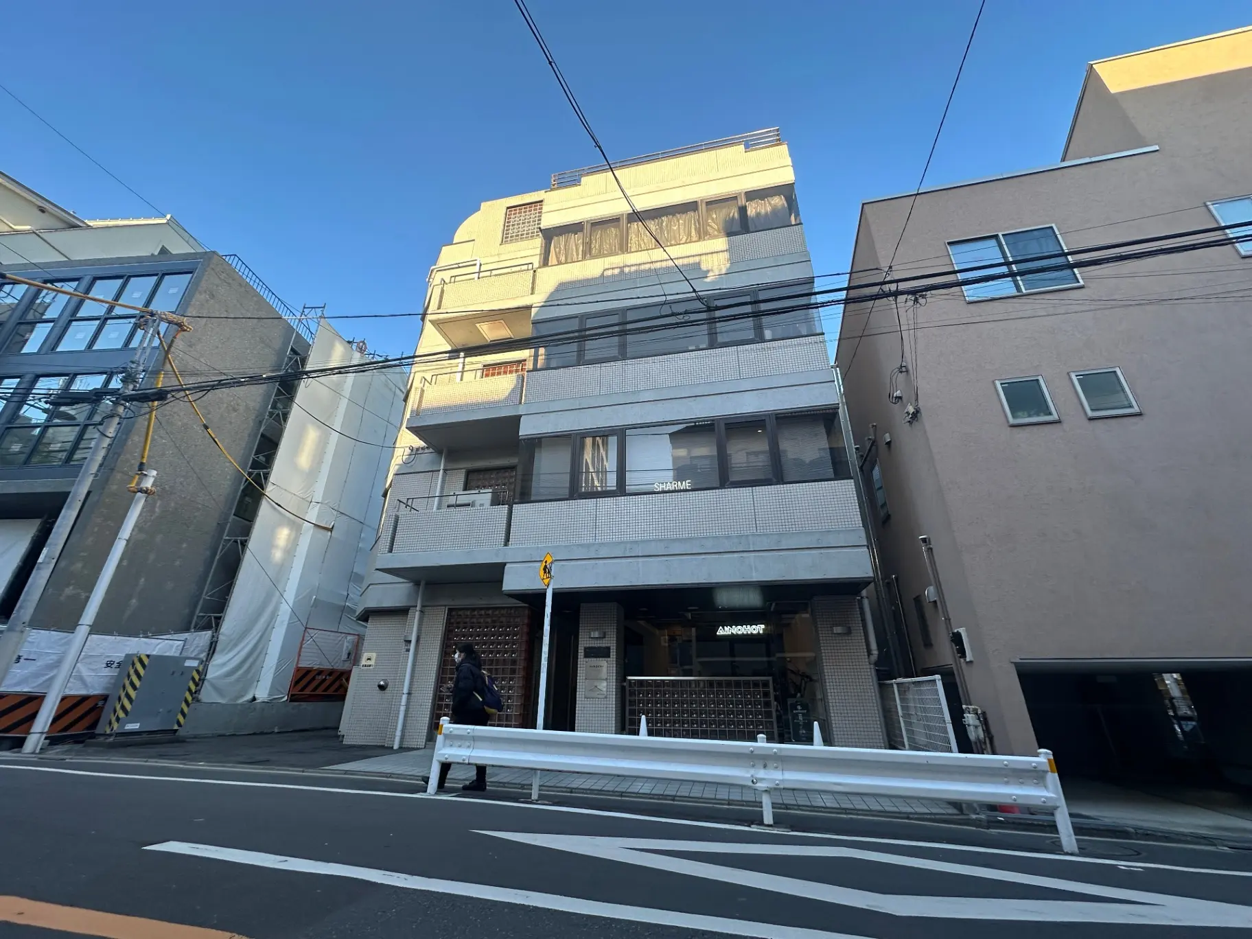 日本の都市部の建物外観、青空と道路の交差点、近代的なデザインのアパートメントと商業施設