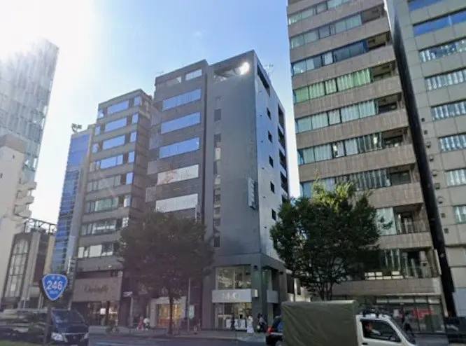 都市のオフィスビルと商業施設が立ち並ぶ通り、晴れた日の青空と高層ビルディング