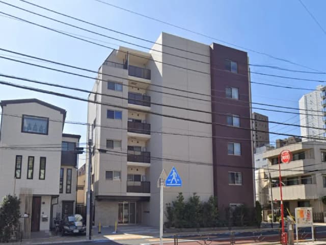 - 都市的な風景にある現代的なマンション、異なるデザインの住宅が隣接し、晴れた青空の下で映える景観