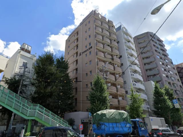 - 高層マンションと周辺の建物、緑の木々と青空のコントラスト、街の風景を捉えた画像