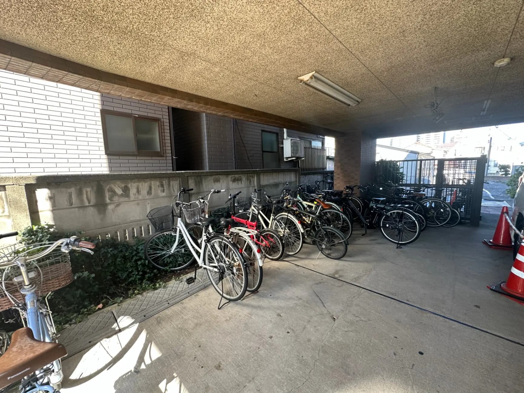 アパートの駐輪場、屋根付きで駐輪スペースが多数、自転車が整然と並んでいる光景