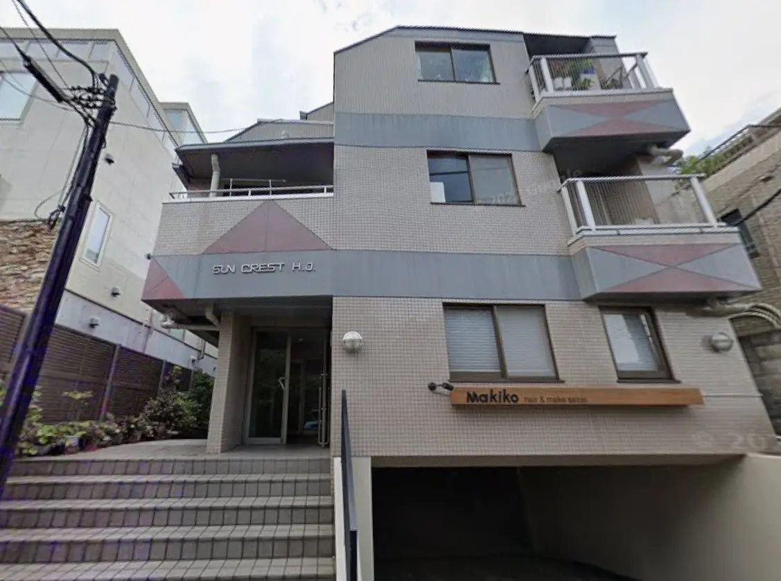 現代的な外観の集合住宅、階段とエントランス、地上階に美容室の看板