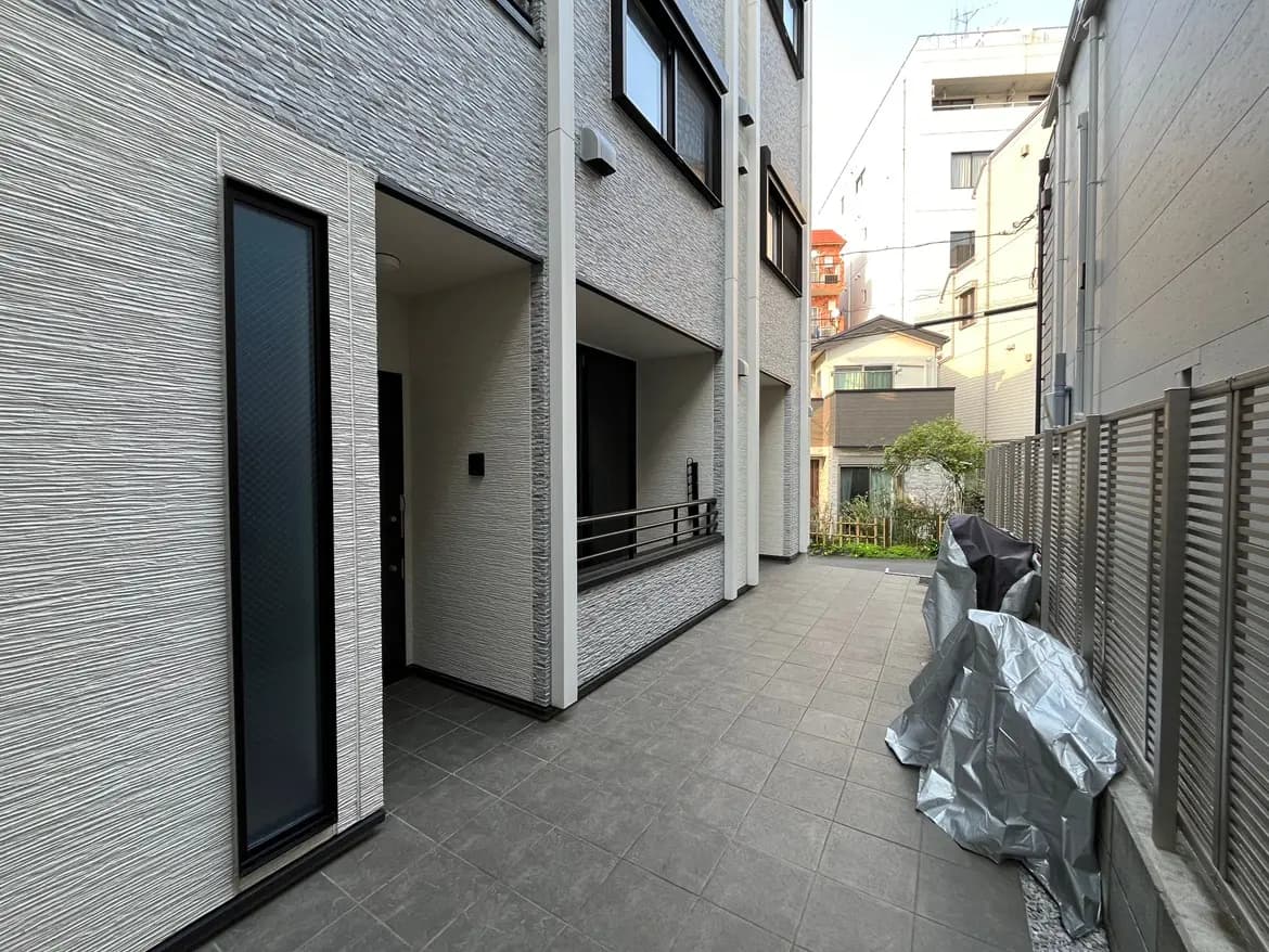 現代的な外観の都市型住宅、グレーのタイル張りのファサード、庭園の見えるプライベートドライブウェイ