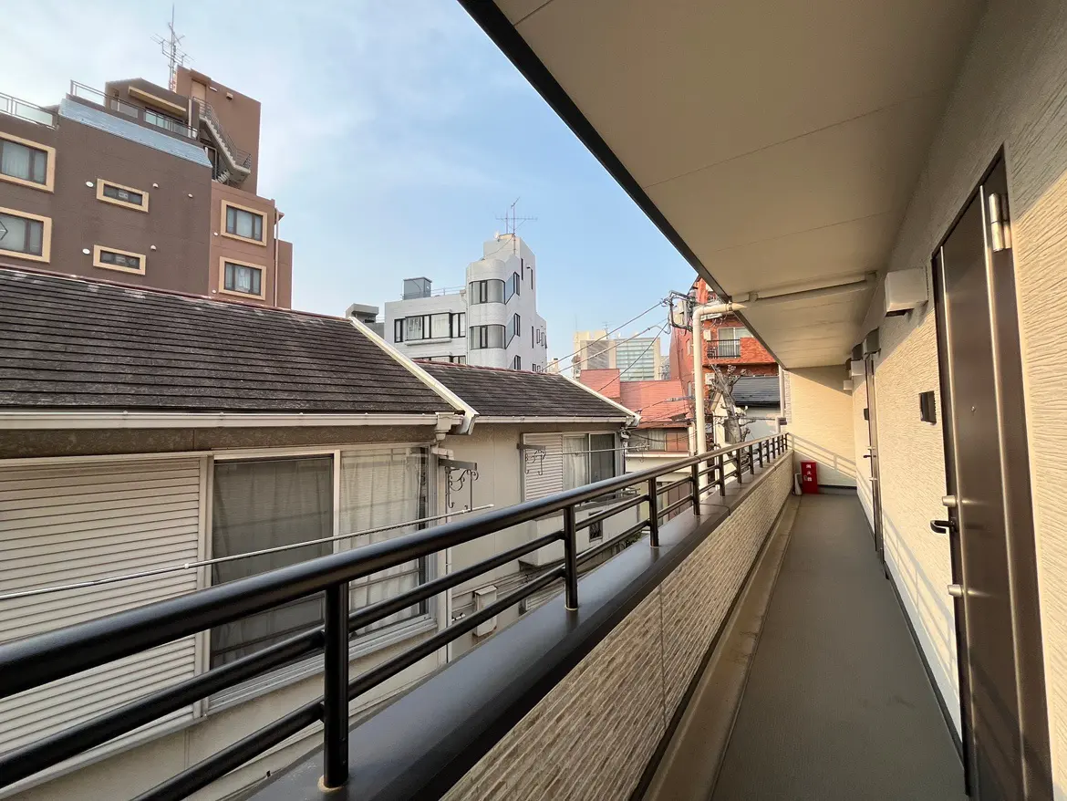 日本の都市のアパートのベランダからの眺め、昼間の晴れた日、建物と空の景色