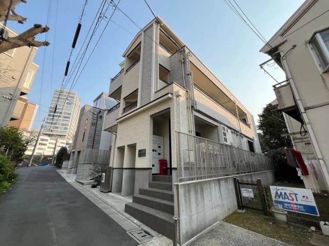 現代的な外観の都市型住宅、明るい色のファサード、道路に面した階段とフェンスがあるエントリー