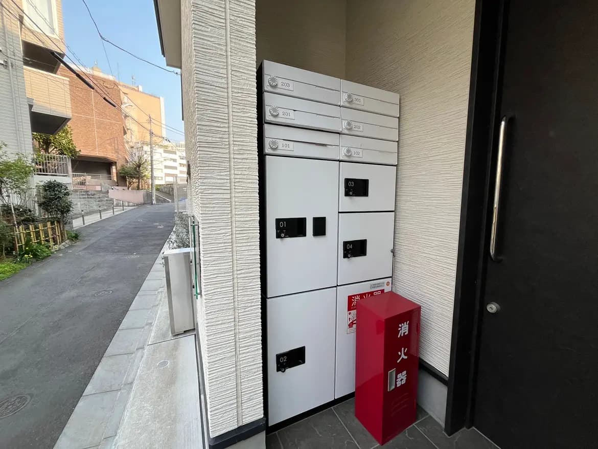 集合住宅のエントランス横に設置された宅配ボックスとポスト、清潔で安全な住宅環境