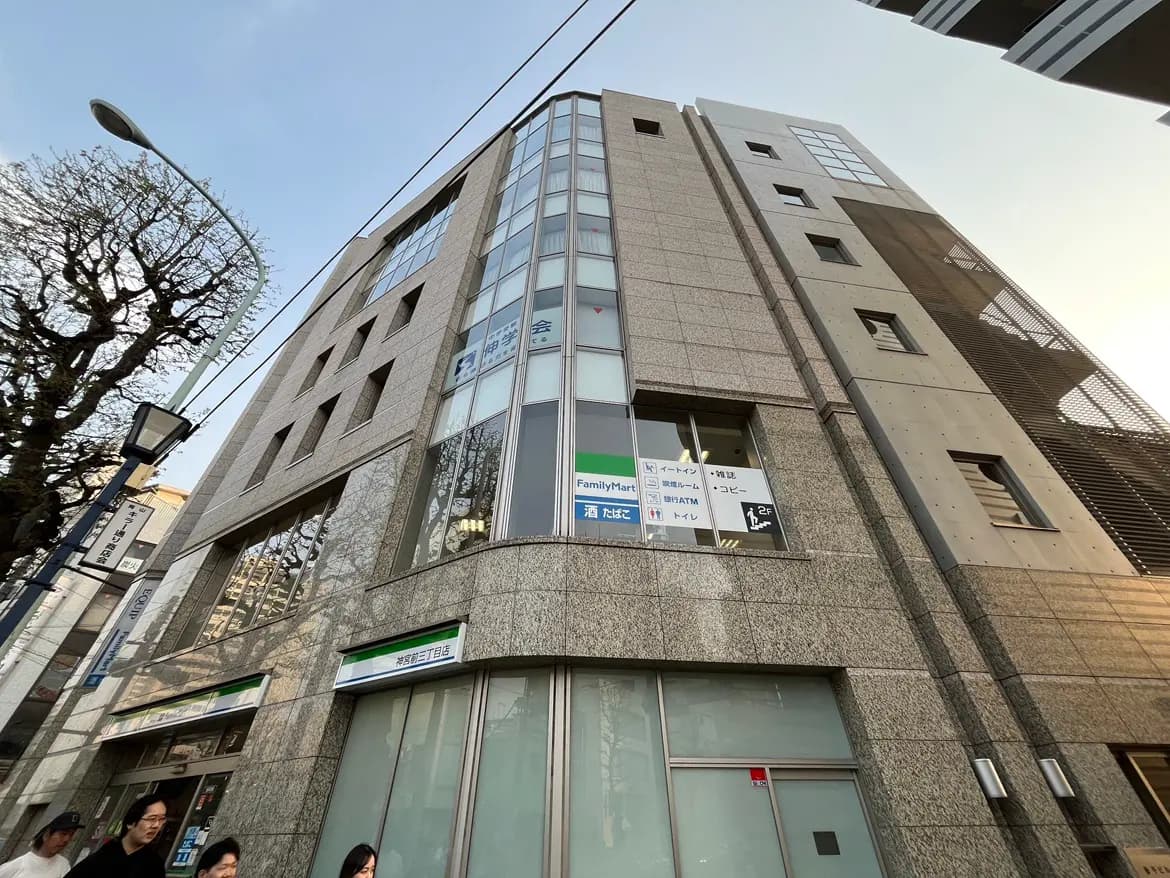 現代的な建築のオフィスビル外観、街路樹と街灯、明るい時間帯の写真