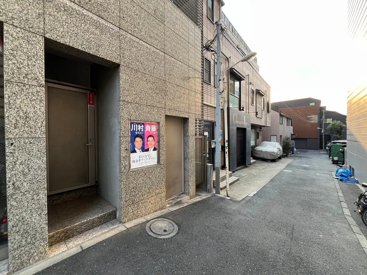 日本の都市の路地、石造りの建物と店舗、夕日に照らされた静かな雰囲気