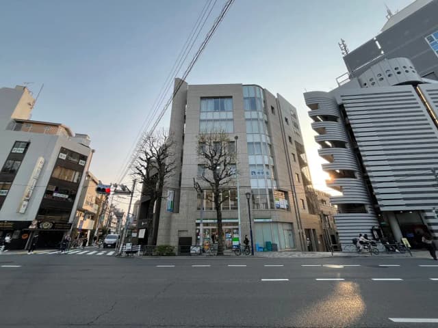 日没時の都市風景、交差点と近代的な建物、人々と自転車、青空