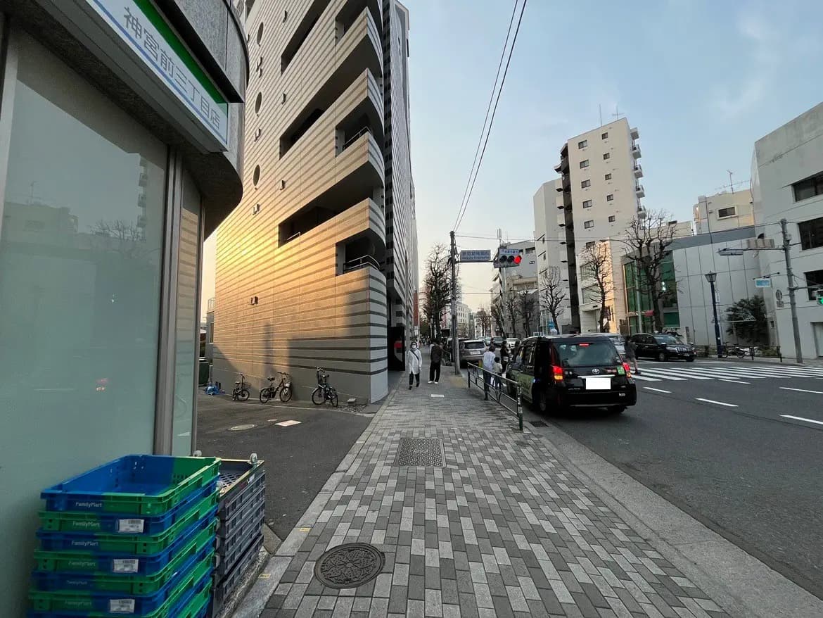 都市の交差点、歩行者と移動する車、夕暮れ時の街並みと建物の様子