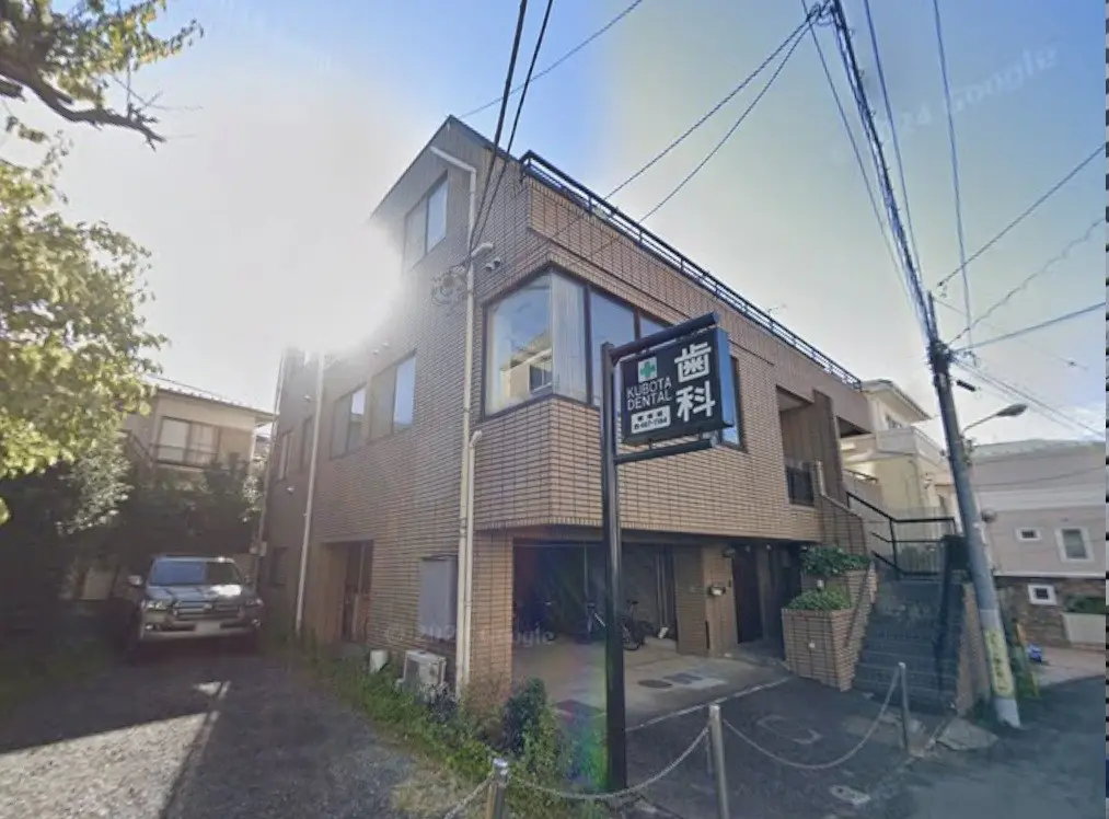 日差しが差し込む街角にあるモダンなレンガ造りの歯科医院の外観