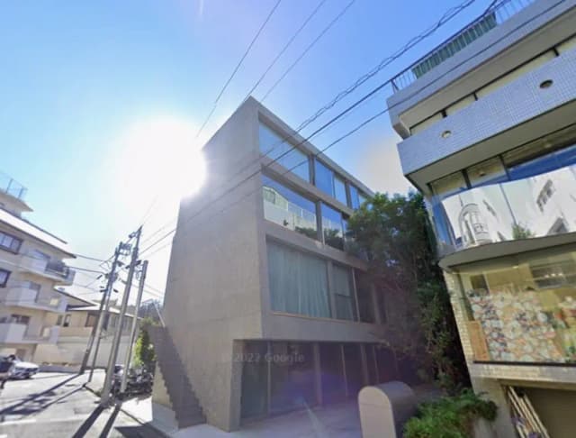 日差しを浴びるモダンな都市の建物、ガラス張りのファサードとコンクリートの壁